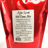 A red resealable pouch of Aztec Spiced Artisan Hot Cocoa Mix with a white label showing product details and instructions.