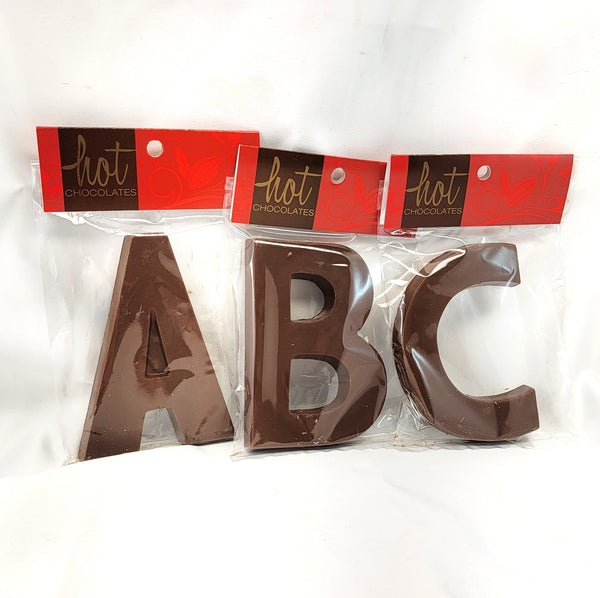 Three large chocolate letters A, B, and C in artisan single origin milk chocolate, individually packaged in clear plastic bags with red and black cards labeled 'hot CHOCOLATE'.