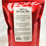 A 300g bag of Traditional Artisan Hot Cocoa Mix, showing the back of the red resealable packaging with a white label containing product details and ingredients.