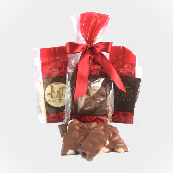 A picture of artisan chocolate almond bark in milk, dark and white Colombian chocolate, bagged in 2 sizes.
