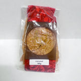 A red, brown and clear bag filled with artisan brittle with a label that reads 'coconut 180g'.