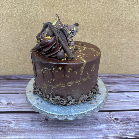 Cakebread Bakery's chocolate lovers dream cake, called the Blackout Chocolate Cake, decorated with rich dark chocolate frosting and curls, with edible gold marbling.