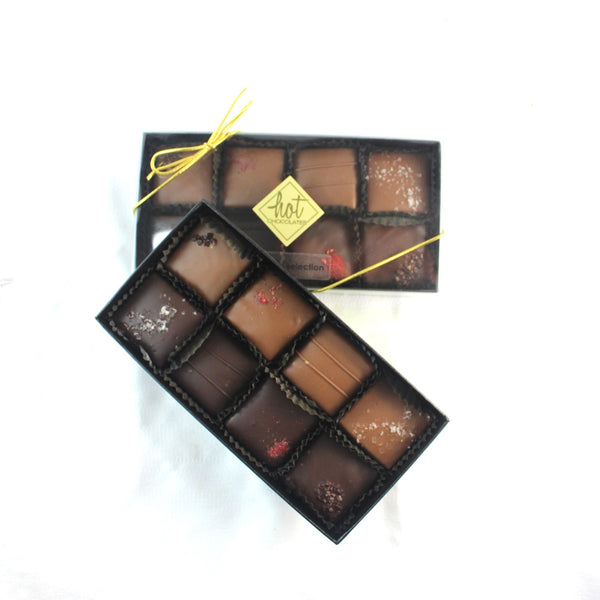 2 artisan handcrafted caramel chocolates selection boxes, with clearly different designs on the chocolates, with Hot Chocolates logo and gold bows on a white background.