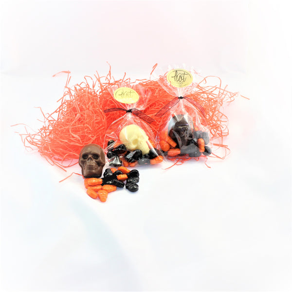 Halloween Skull & Candy Treat Bags with a 2d chocolate skull and black and orange candies on a white background.