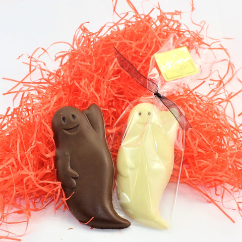 Two Friendly Ghost Halloween Chocolates, one milk and one white, featuring a smiling face design. Packaged in clear, tied with a ribbon.