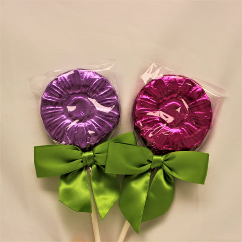 2 milk chocolate flower lollipop suckers foiled in bright purples, finished with a vibrant green bow on each.
