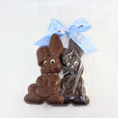 Solid chocolate Easter Bunny named Cuddly, shown in dark and milk chocolate, one packaged in clear with a blue bow.
