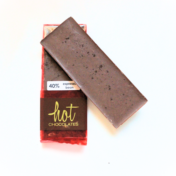 An artisan espresso chocolate bar with a label indicating 40% cacao and visible bits of espresso beans, branded by Hot Chocolates, alongside a second bar partially visible.