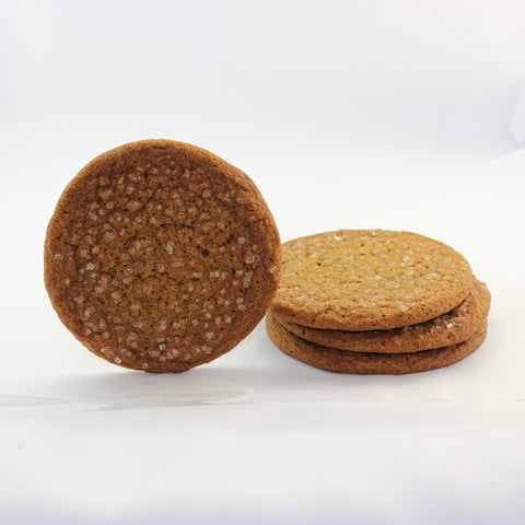 Stack of gourmet chewy ginger cookies with a coarse sugar topping on a white background.
