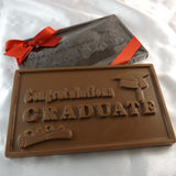 A solid chocolate gift bar with a grad cap and scroll, and text that read 'congratulations graduate' embossed on the front.