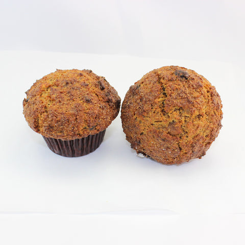 Two healthy fruit & seed bran muffins with visible seeds and dried fruits on a white background.