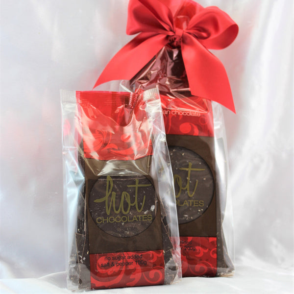 2 bags of No Sugar Added chocolate salt & pepper bark, in red and brown bags, one finished with a big red bow.