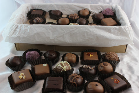 A brown 2lb box of perfectly imperfect 'opps' chocolates, with 2 layers, showing artisan hand-dipped truffles and caramels.