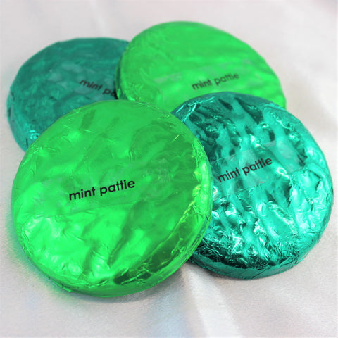 A collection of wrapped artisan chocolate peppermint patties with green wrappers, labeled 'mint pattie'.