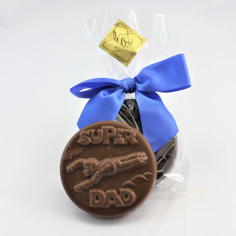 A Super Dad Chocolate Gift Coin in milk chocolate, with a packaged coin behind it, finished in a blue bow.