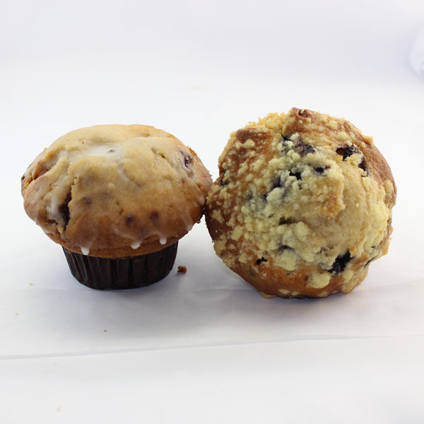 Two seasonal fruit dessert muffins with a choice of topping, one with a lemon glaze and one with a crumble topping, displayed on a white background.