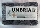 A dark blue and silver bag of coffee beans from Caffe Umbria, labeled med-dark roast and decaffeinated.