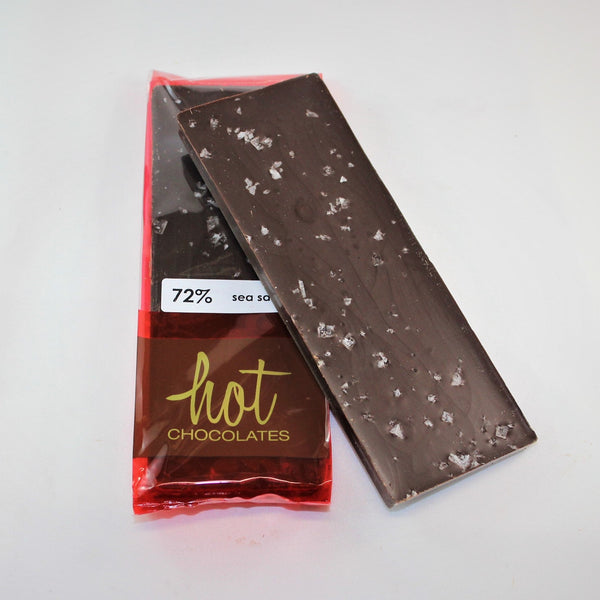 An artisan sea salt dark chocolate bar topped with Maldon sea salt flakes, packaged in a red wrapper with the brand 'Hot Chocolates' visible.