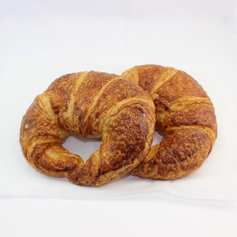 Two golden brown fresh baked butter croissants on a white background