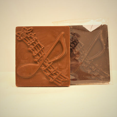 A music notes chocolate gift bar with music notes embossed across the front, shown in milk and dark chocolate on a white background.