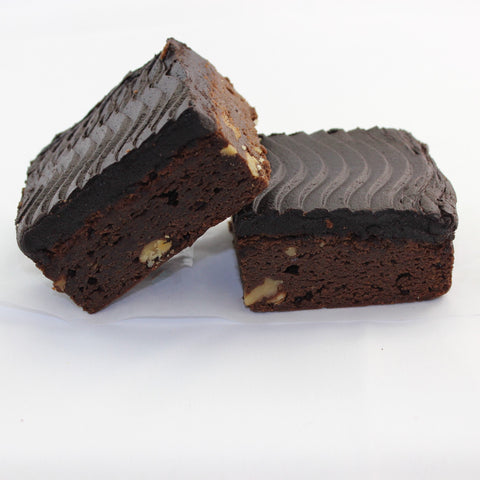 2 dark, rich chocolate walnut brownies on a white background, with thick fudgy frosting.