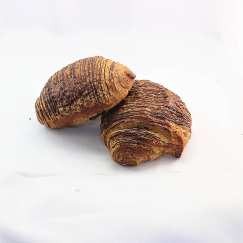 Two artisan chocolate croissants, also known in french as pain au chocolat on a white background.