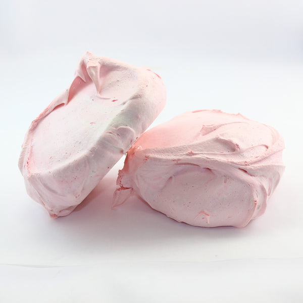 Two pink classic seasonal flavoured meringue cookies on a white background, these in strawberry flavour.