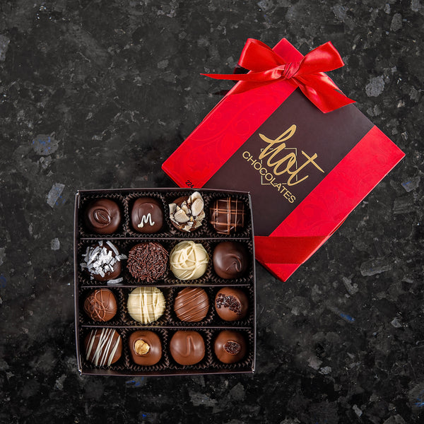 A box of 16 custom picked hand-dipped chocolates from Hot Chocolate, in a dark brown and red box with a red bow.