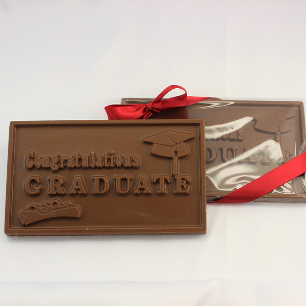 2 solid chocolate gift bars that read ' Congratulations Graduate', finished in clear packaging with a red bow on a white background.