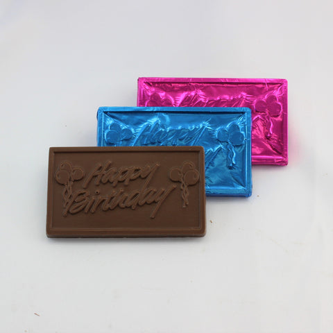 Three rectangular foiled Chocolate Happy Birthday Bars with 'Happy Birthday' text on them, in chocolate, blue, and pink wrappers