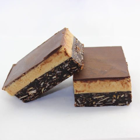 2 creamy peanut butter Namaimo bars, stacked on a white backdrop, with 3 distinct layers in this classic Canadian dessert bar. 