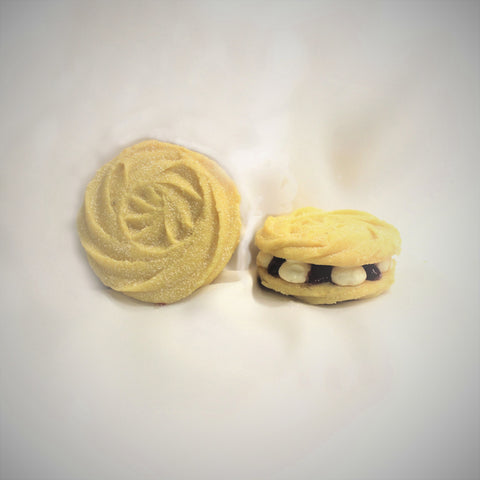 2 Viennese whirl cookies with raspberry cream cheese filling on a white background.