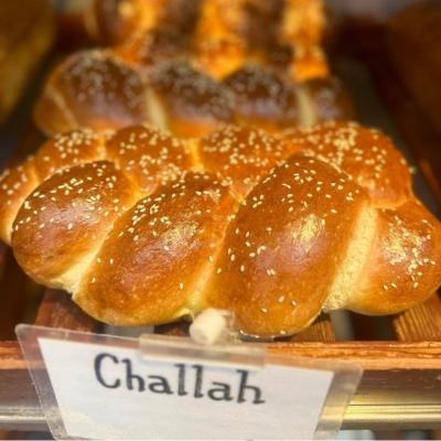 Freshly baked artisan loaves of bread on a shelf at Cakebread Artisan Bakery.